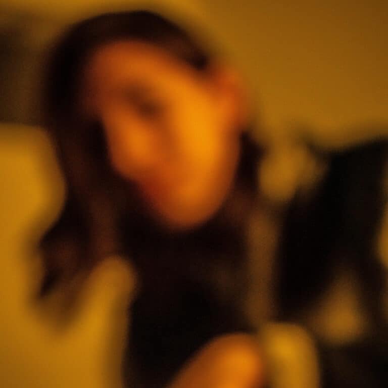 Out-of-focus photograph of a person with high noise levels and yellow color tint.